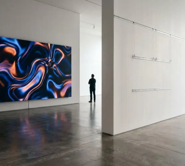 Contemporary gallery interior showcasing digital screen-based artwork installation alongside empty traditional canvas wall space