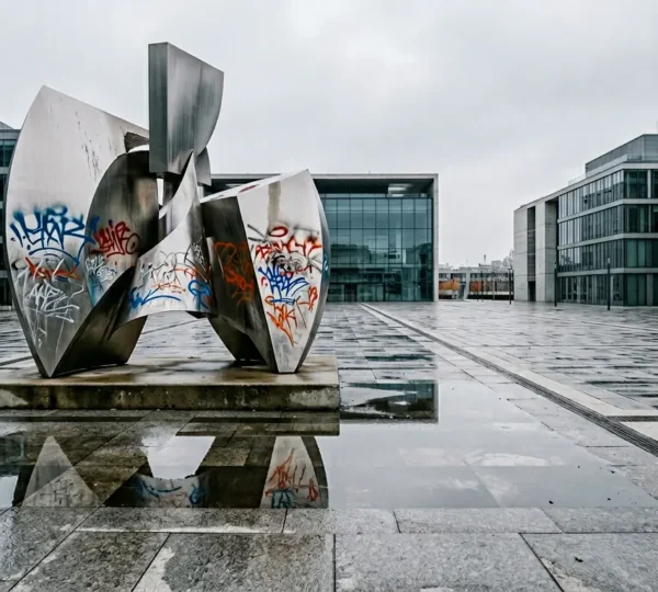 Expensive public sculpture showing signs of vandalism in urban setting