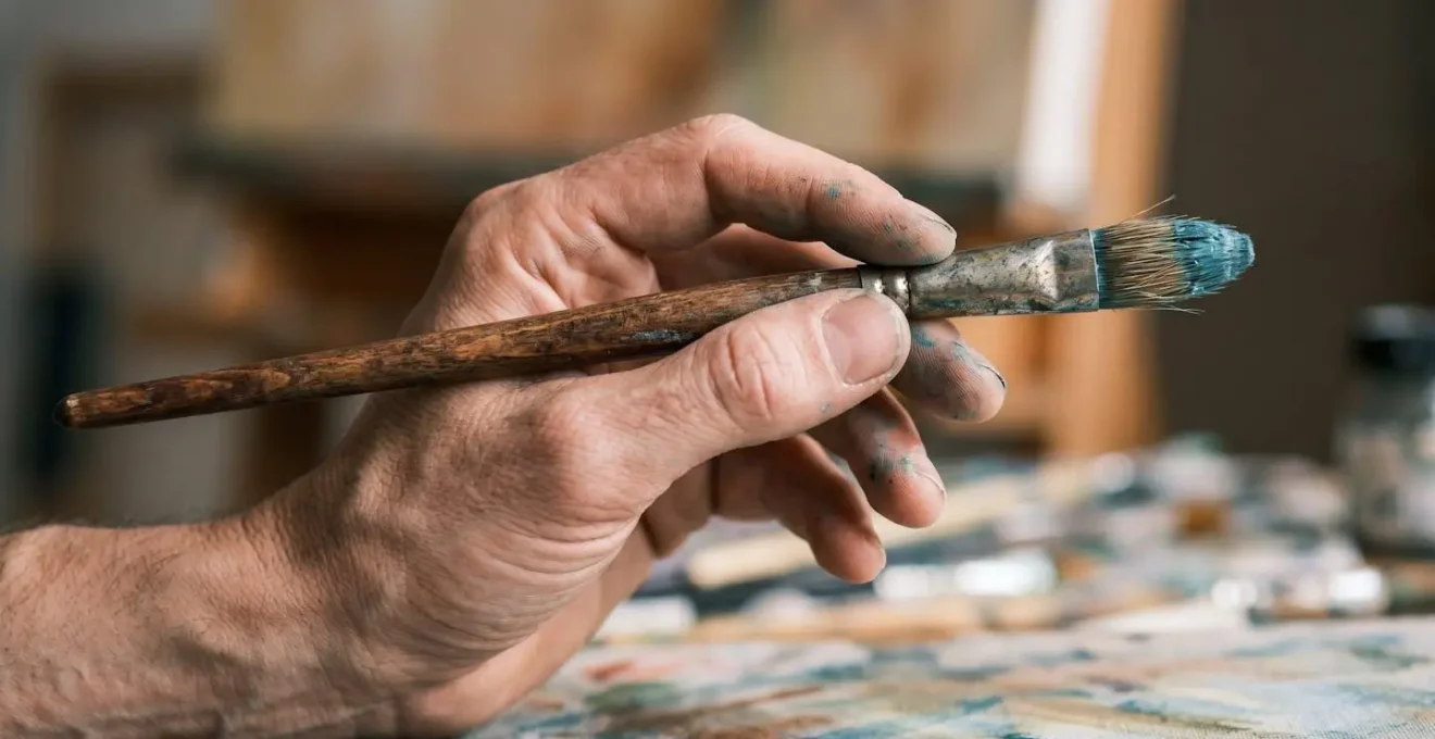 Detailed macro view of artist hand demonstrating proper brush grip technique