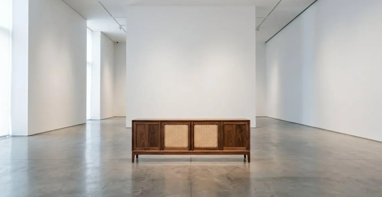Minimalist gallery setting showcasing high-end designer furniture piece in premium retail environment with professional lighting and clean spatial design