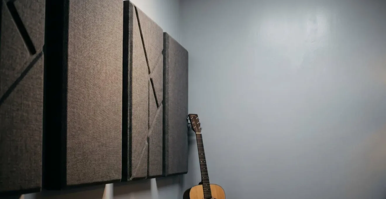 Minimalist music practice room showing acoustic panel placement strategy with absorptive materials on front wall and reflective surfaces on rear wall
