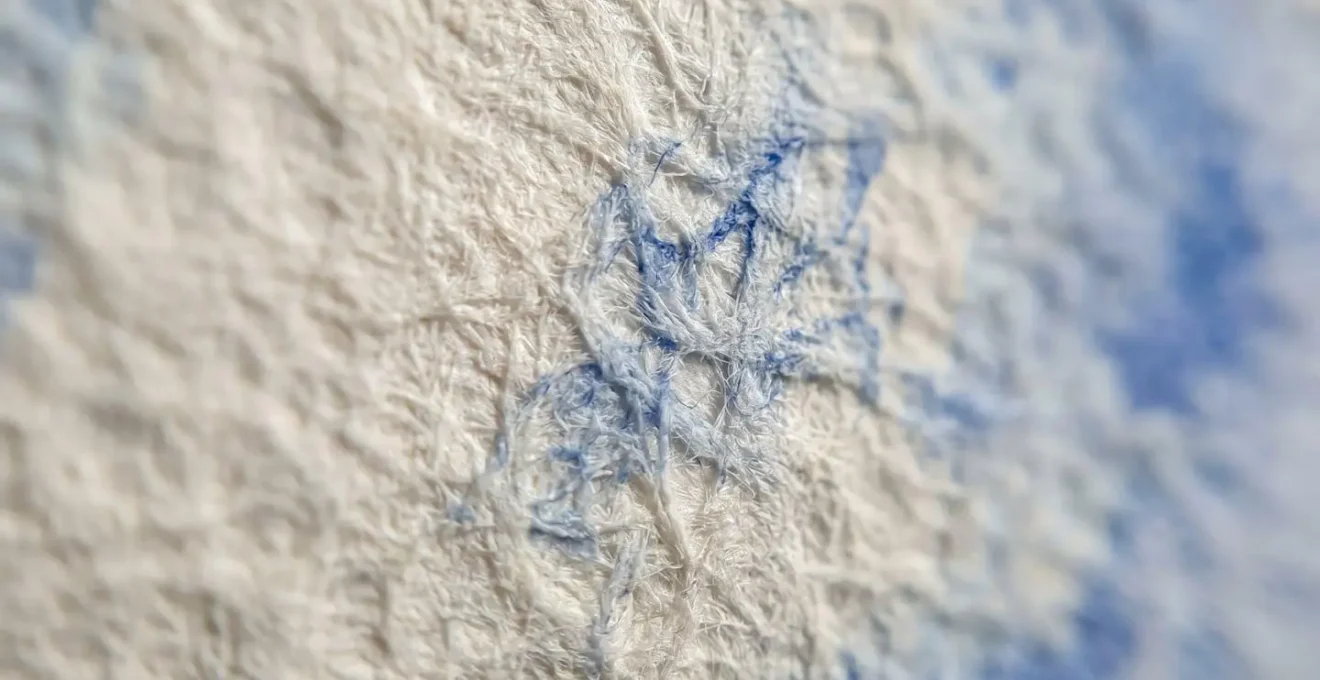 Extreme close-up macro photograph of watercolor paper texture showing fiber detail and paint absorption for digital art reference